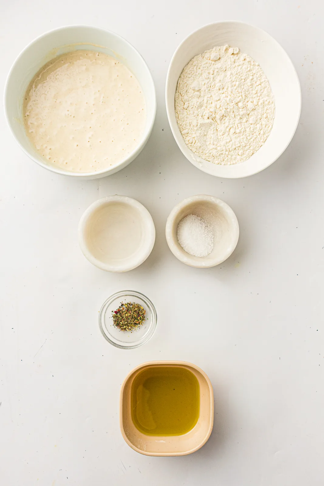 Ingredients for sourdough discard crackers: starter, flour, olive oil, salt and dried herbs