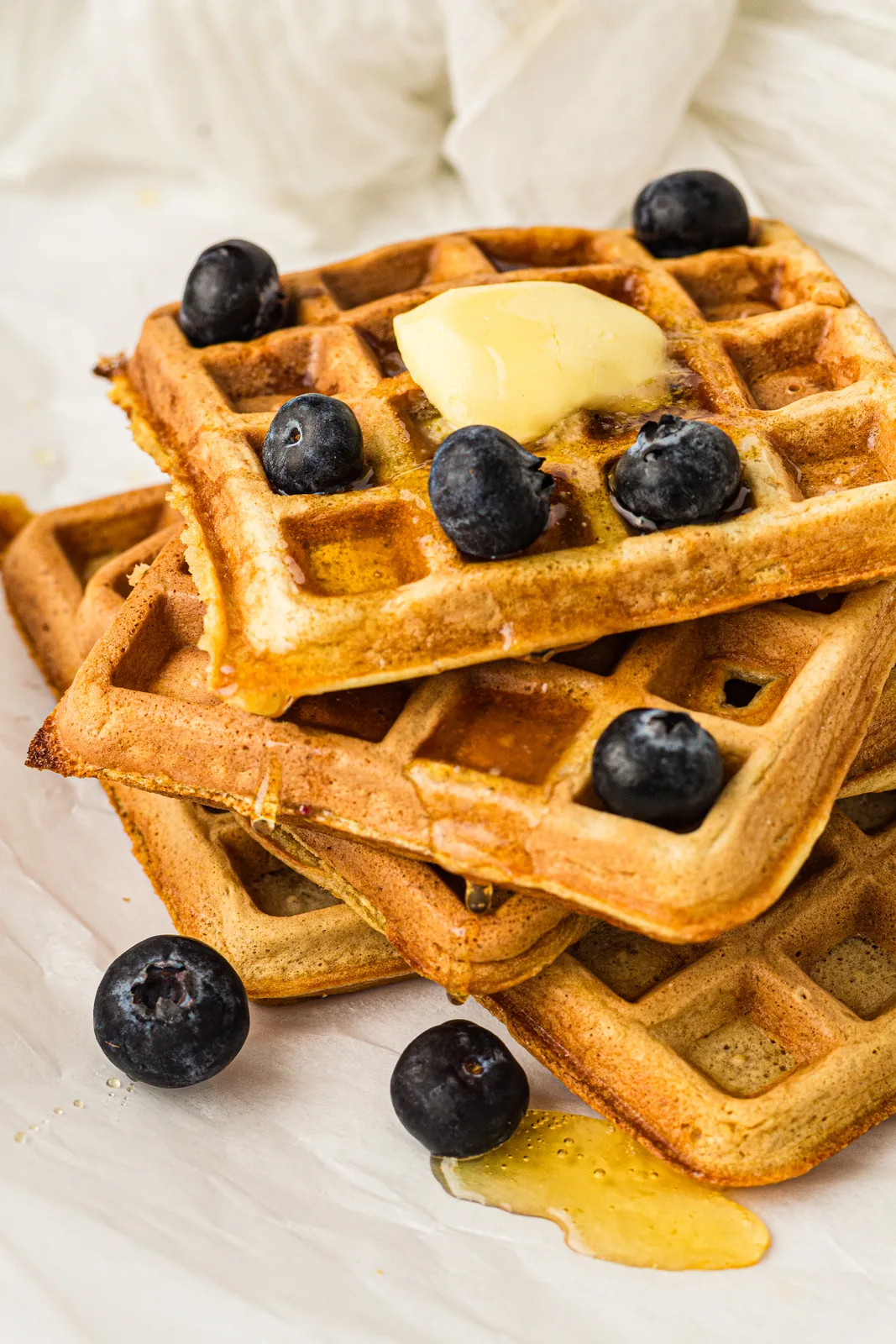 A stack of sourdough discard waffles with blueberries and butter