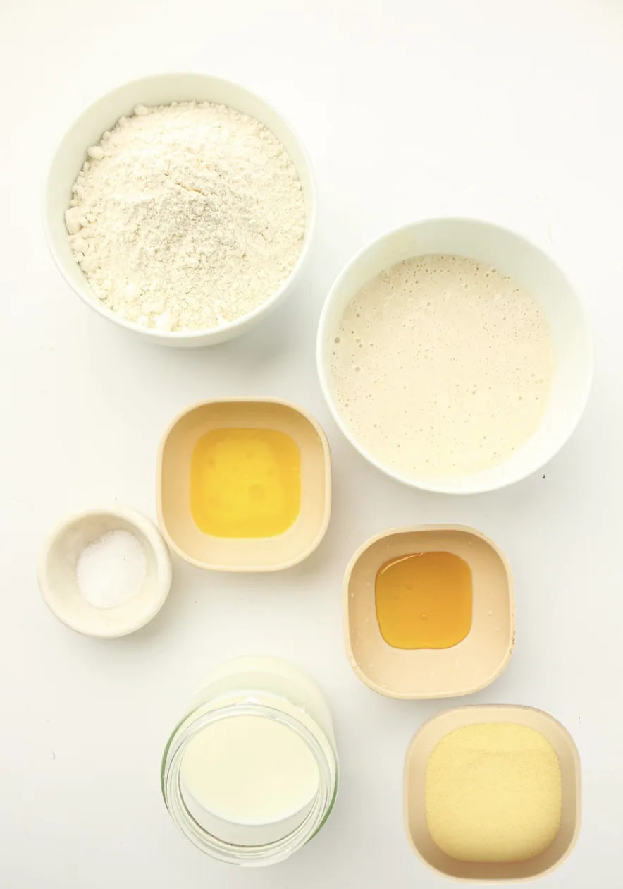Ingredients for sourdough english muffins: starter, milk, plain flour, butter, salt, honey and semolina
