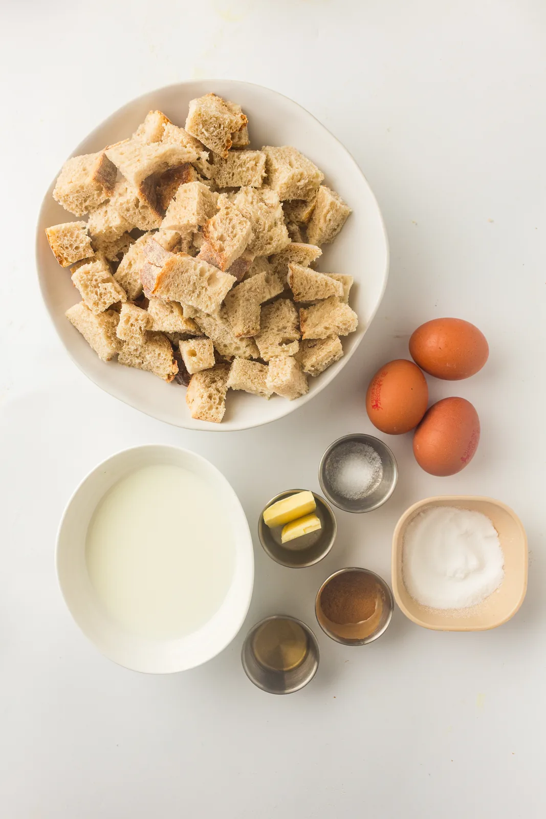 Ingredients for sourdough french toast casserole: cubed bread, eggs, milk, sugar and spices