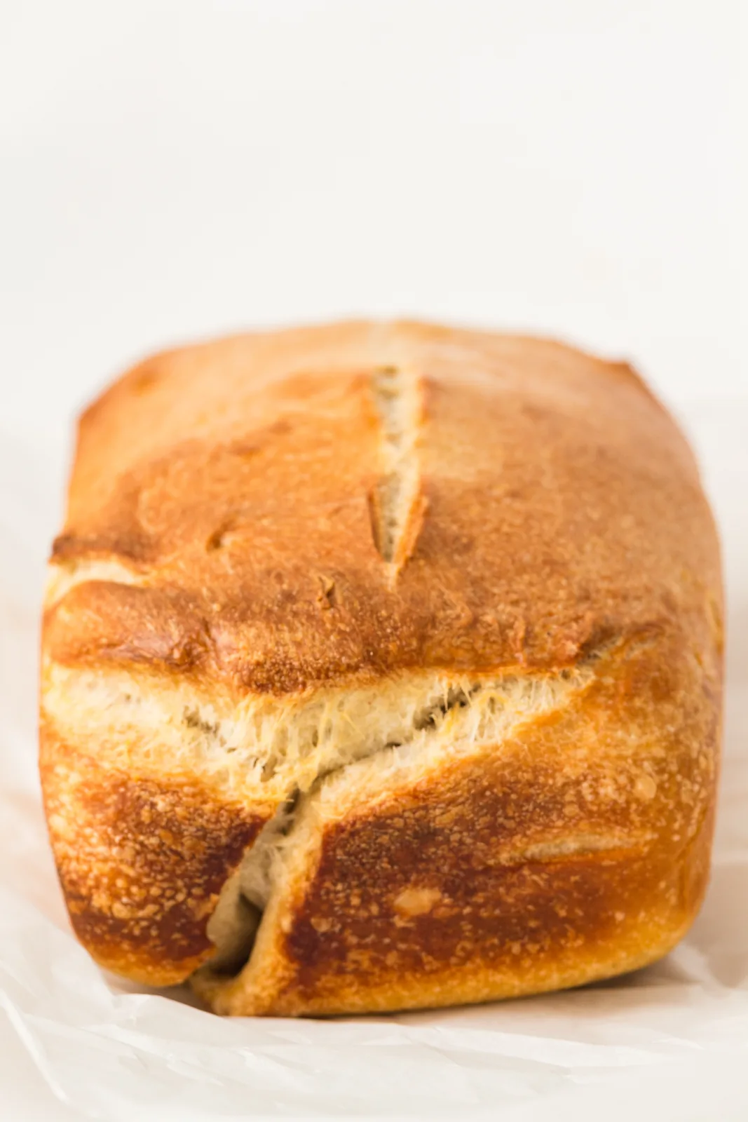 Sourdough sandwich bread baked in a tin and cooling on parchment