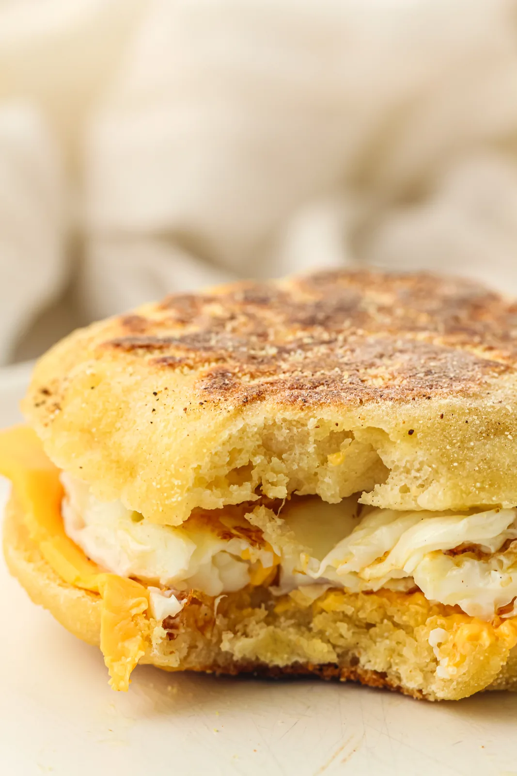 A split round filled with a fried egg and melted cheese
