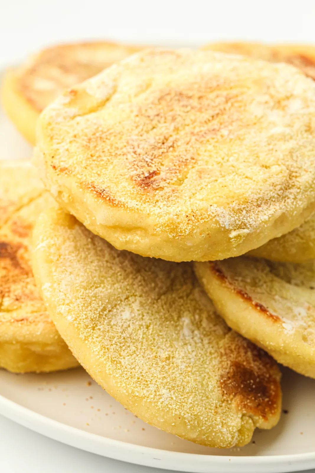A stack of semolina dusted rounds on a white plate