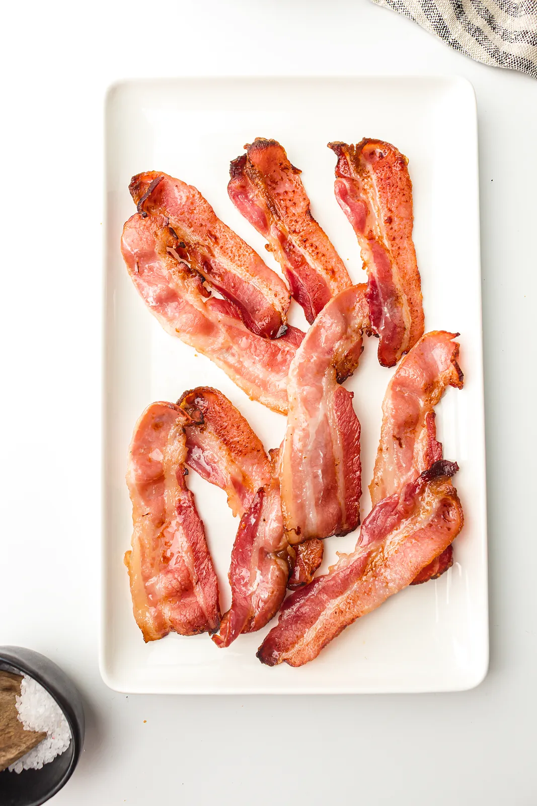 Crispy air fryer bacon rashers arranged on a long white platter