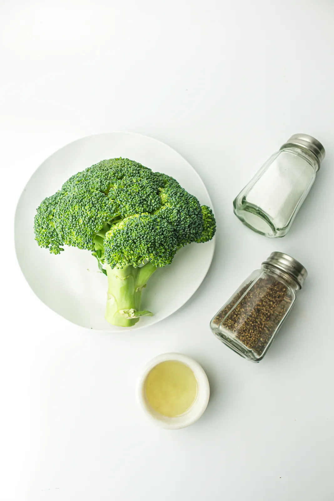 Ingredients for air fryer broccoli: a head of broccoli, avocado oil, salt and pepper