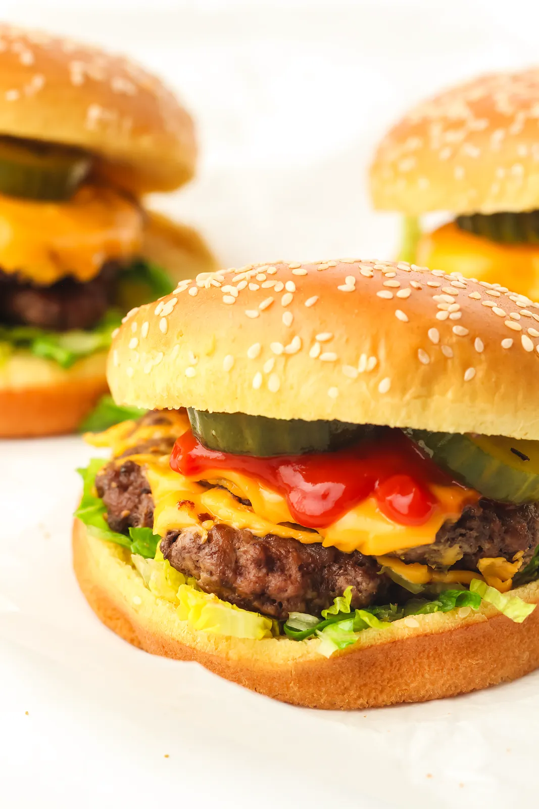 Blackstone smash burgers with melted American cheese, pickles and ketchup on sesame buns