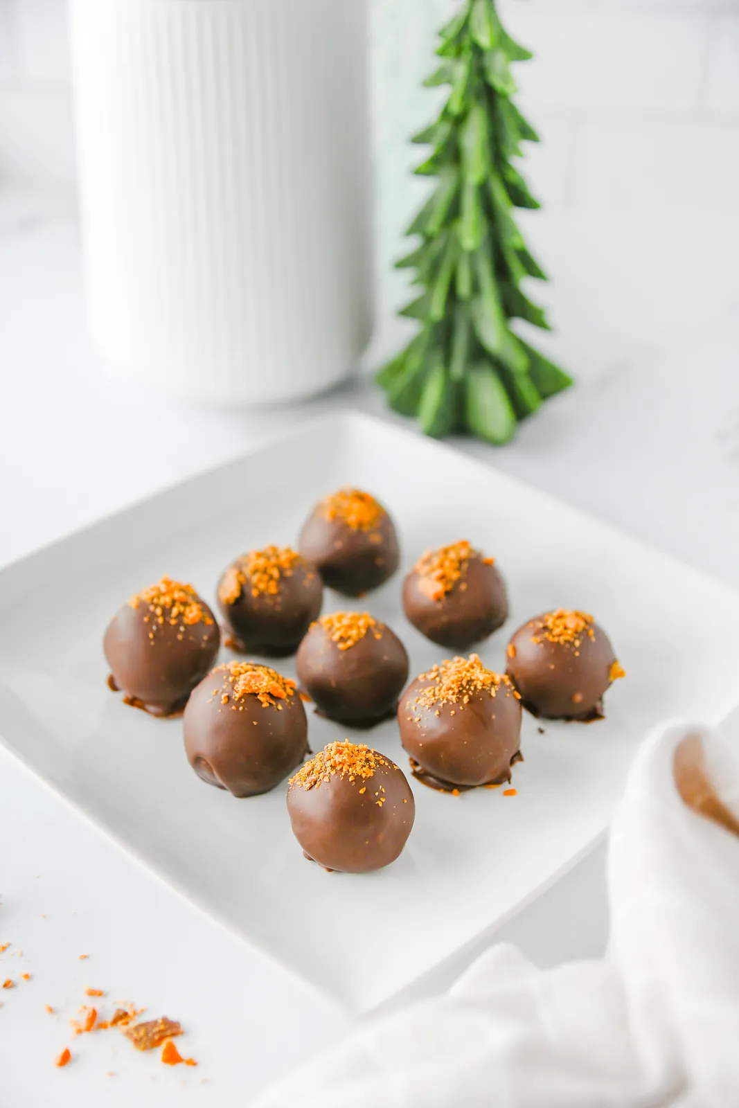 Butterfinger balls with orange candy crumbs on a white plate