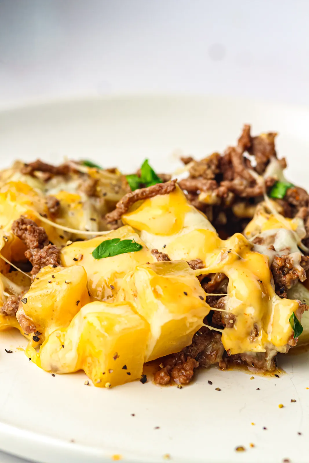 A plate of cheesy potato and beef with parsley