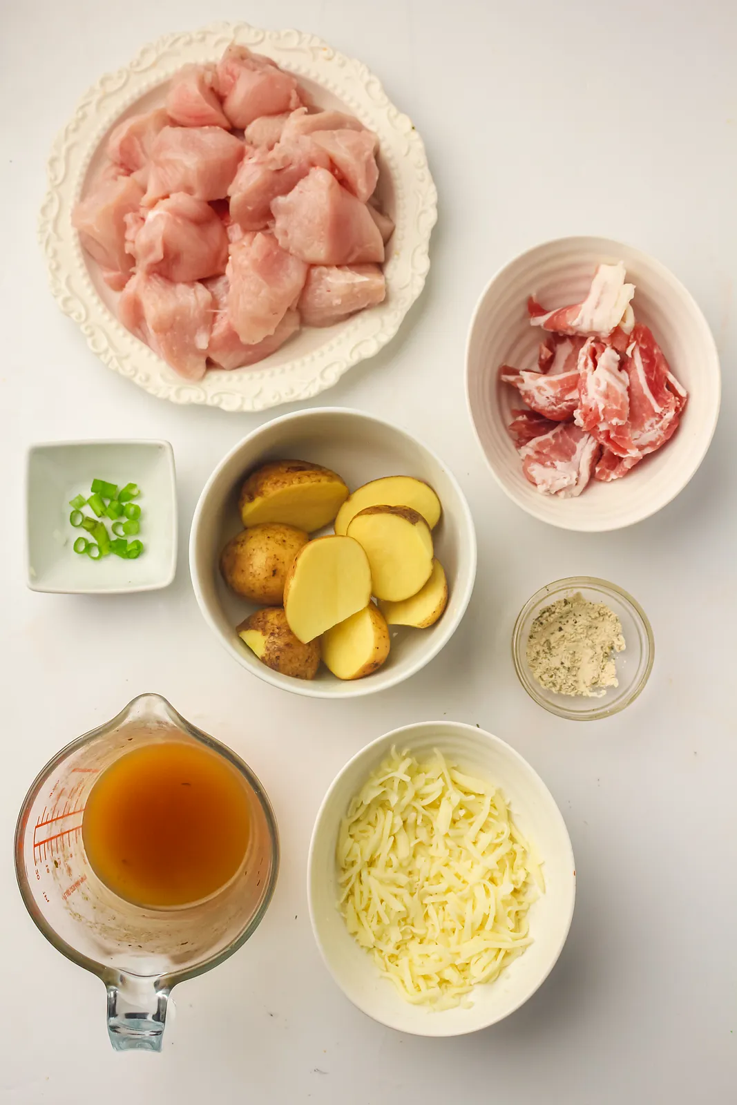 Ingredients for chicken bacon ranch: diced chicken, bacon, baby potatoes, ranch seasoning, stock, cheddar and green onions