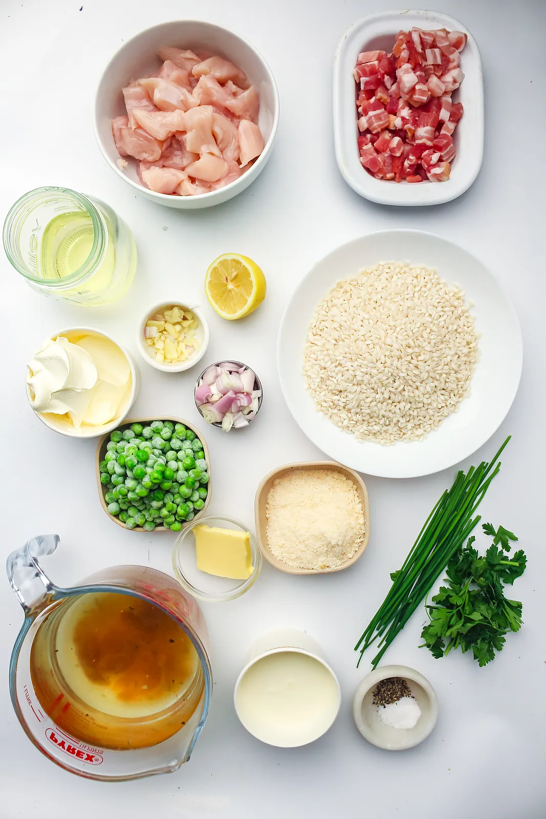 Ingredients for chicken risotto: chicken thighs, smoked bacon, arborio rice, stock, peas, mascarpone, Parmesan, lemon and herbs
