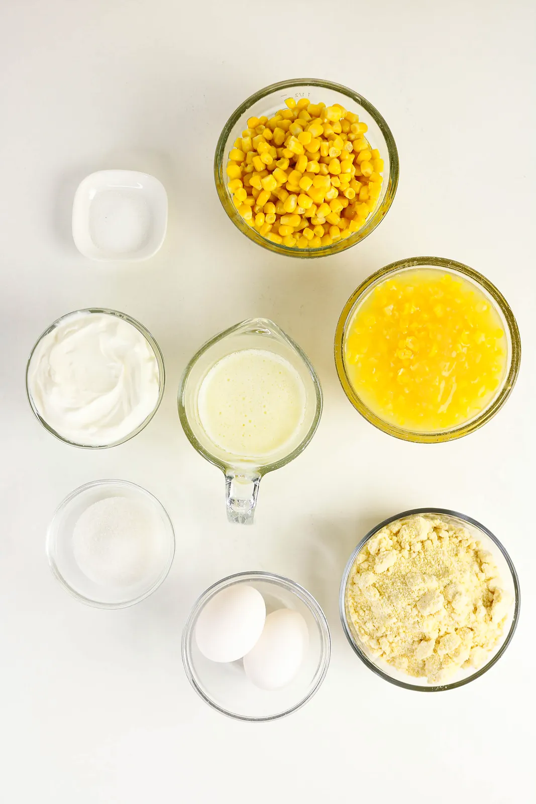 Ingredients for corn souffle: whole kernel corn, creamed corn, sour cream, melted butter, eggs, cornbread mix, sugar and salt