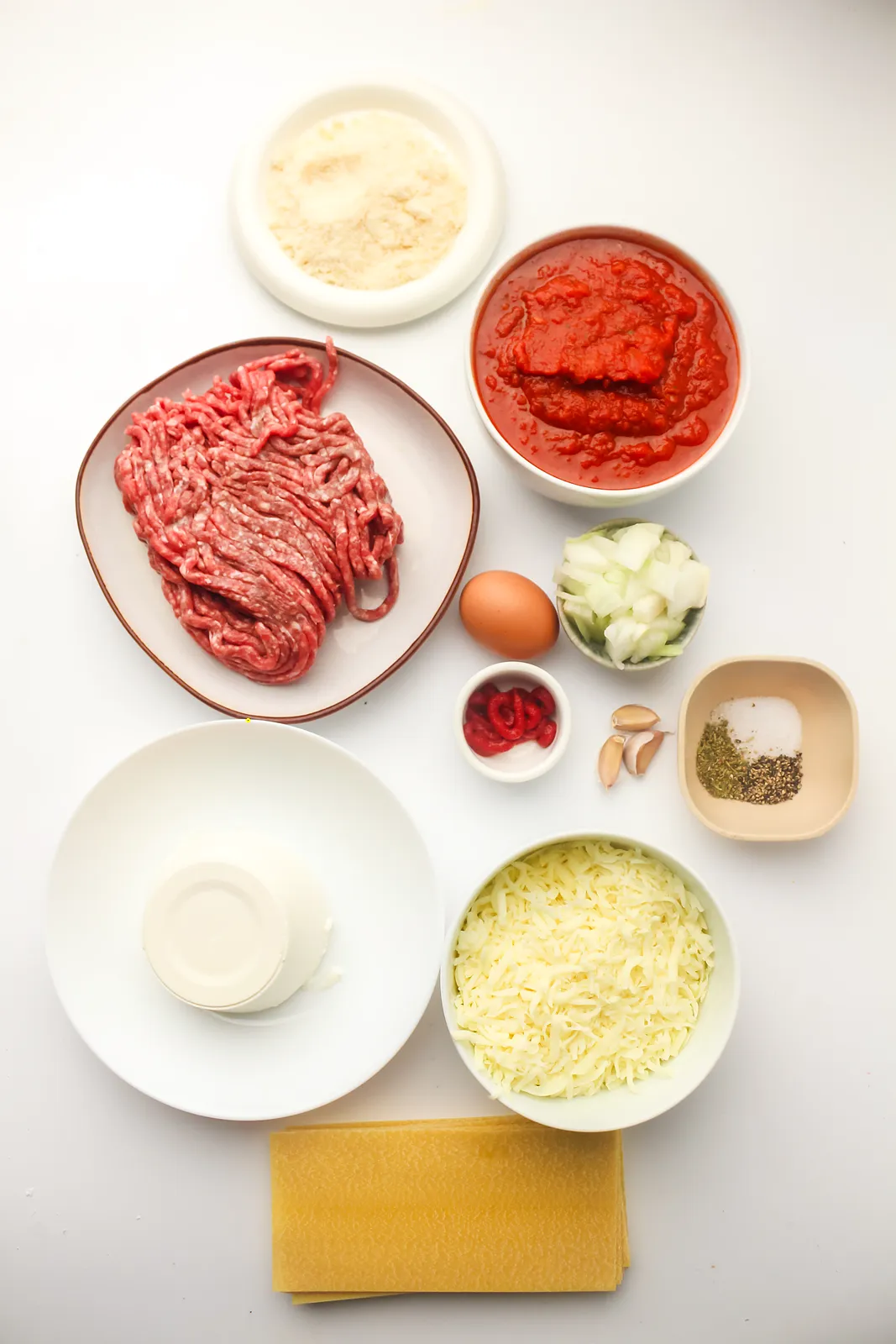 Ingredients for crockpot lasagna: beef mince, marinara, tomato paste, onion, garlic, seasoning, ricotta, egg, Parmesan, mozzarella and pasta sheets