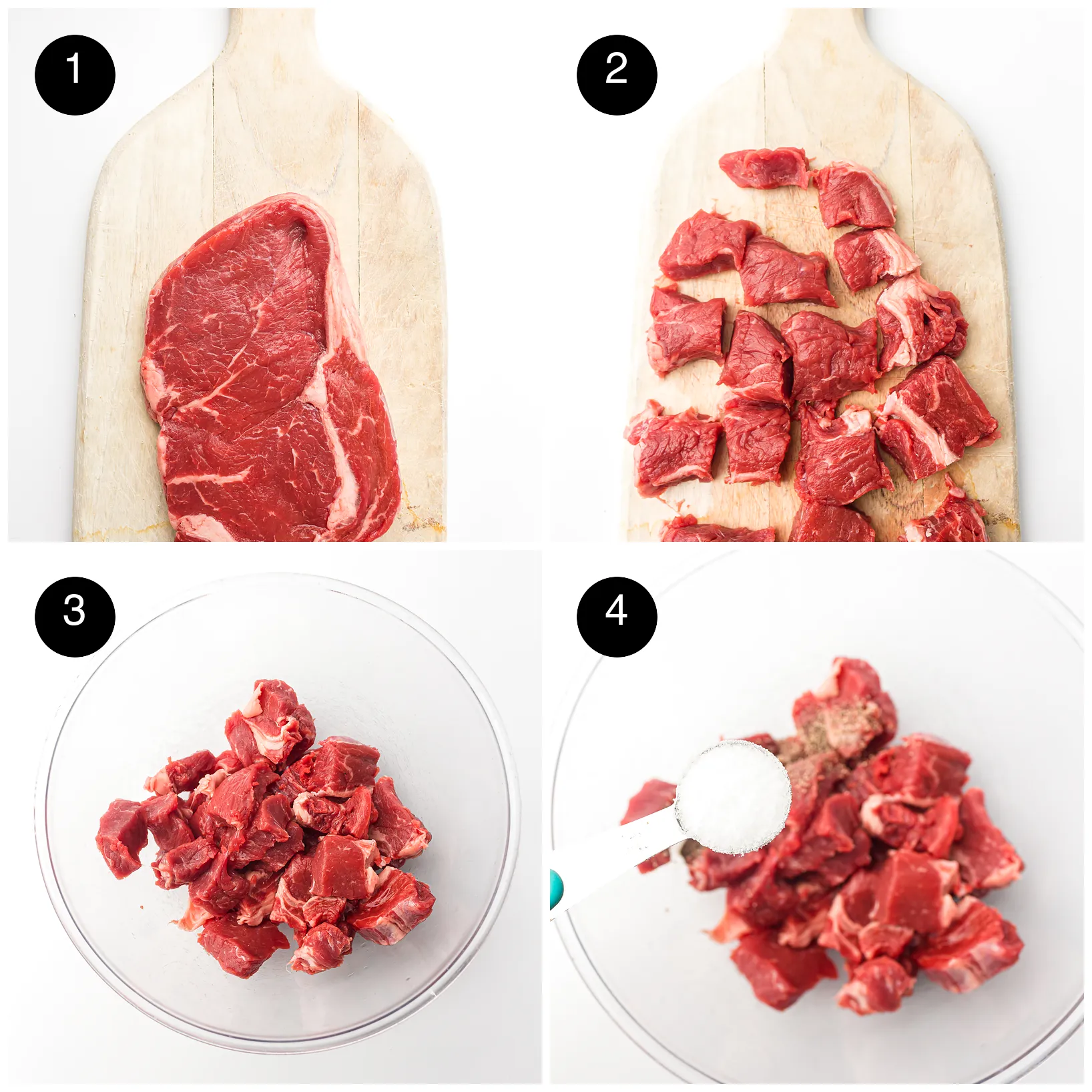 A raw ribeye on a board, cut into cubes, then placed in a glass bowl and salted