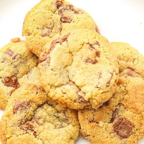 Chocolate chunk cookies baked from freezer cookie dough, piled on a white plate