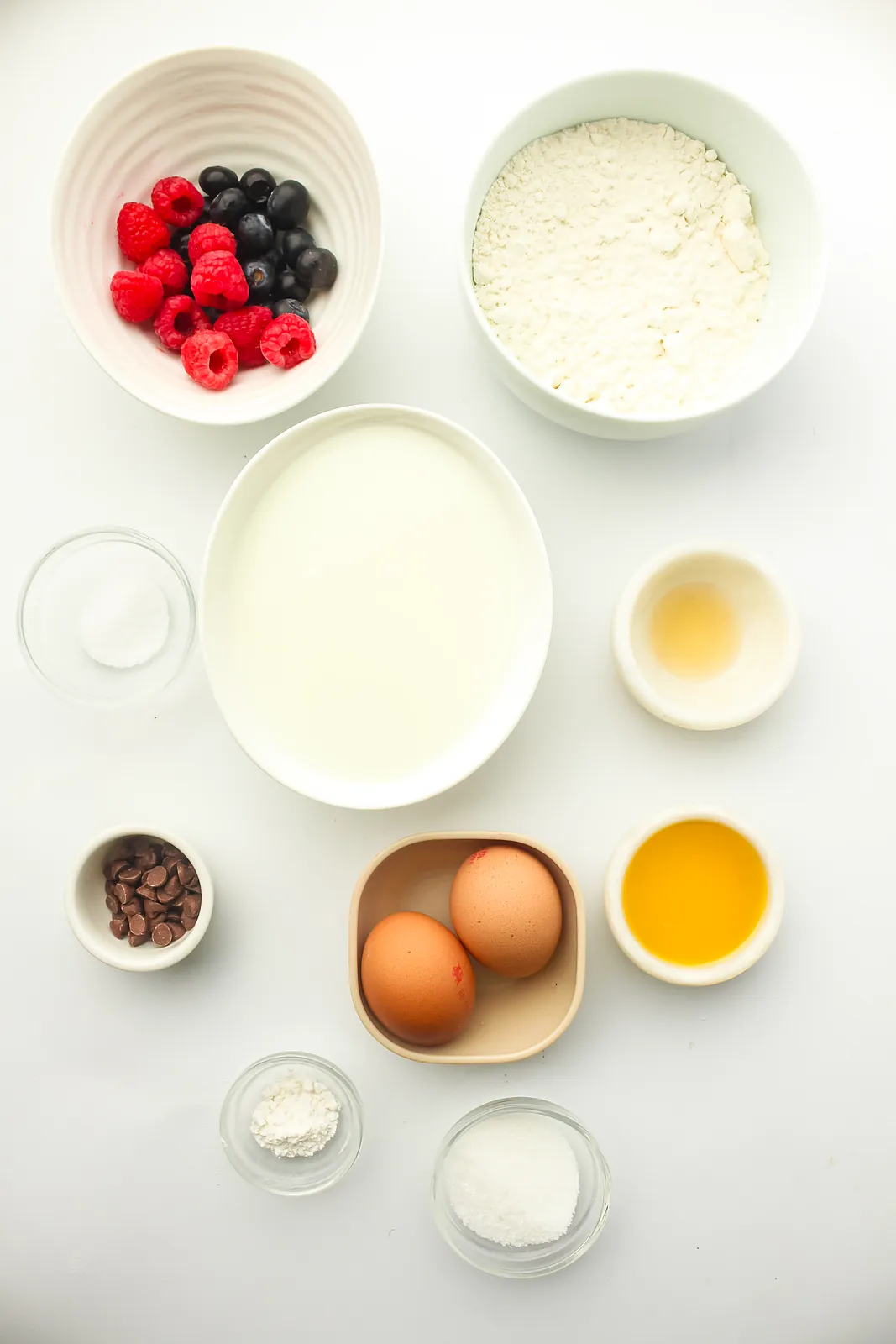 Ingredients for freezer pancakes: flour, milk, eggs, melted butter, vanilla, sugar, baking powder, salt, berries and chocolate chips