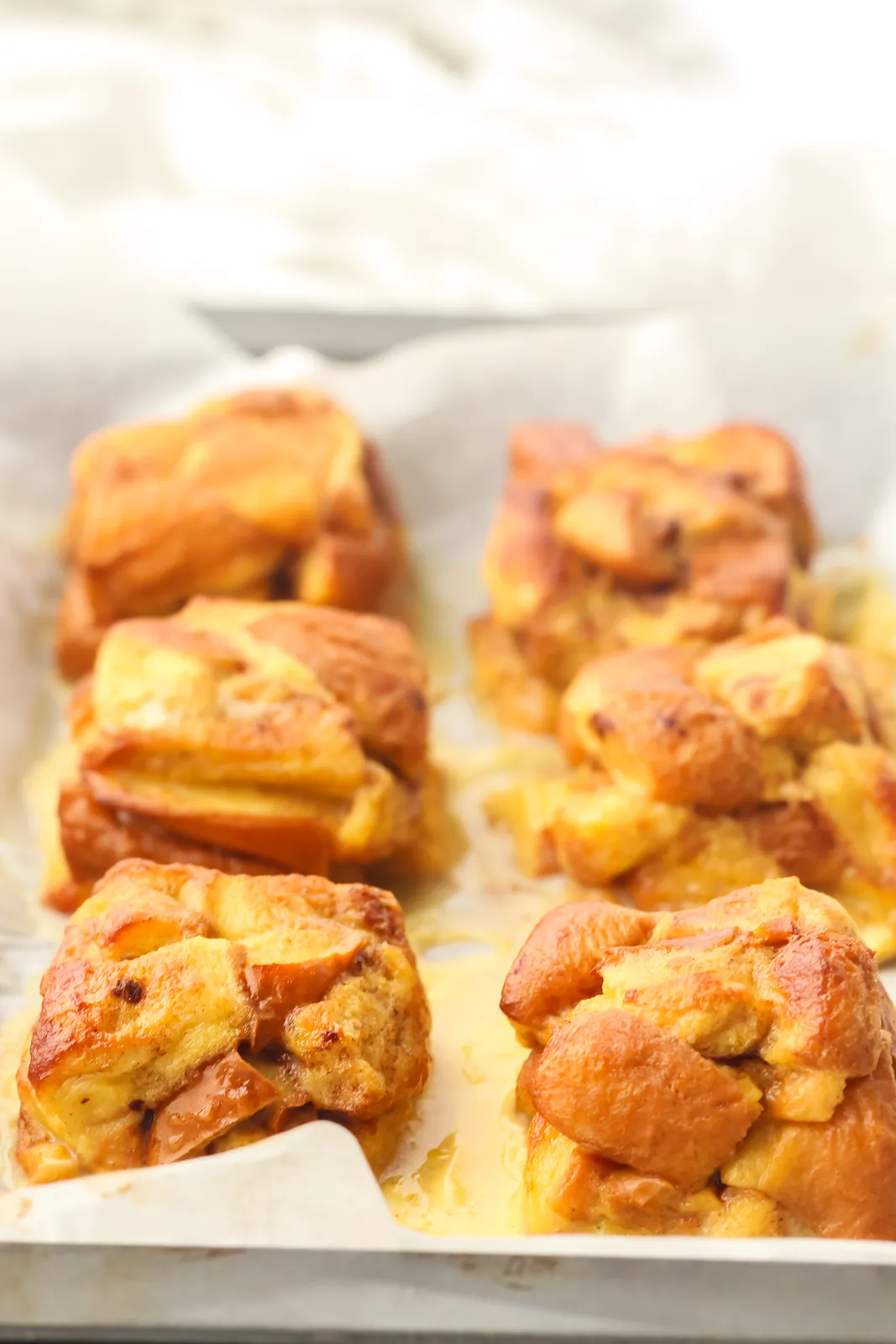Golden, puffed brioche bites straight from the oven on a parchment lined tray