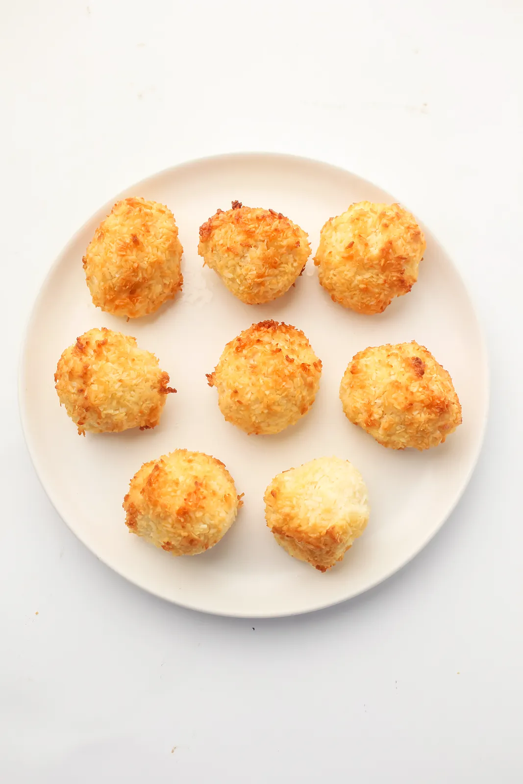 Eight golden toasted mounds on a white plate, seen from above