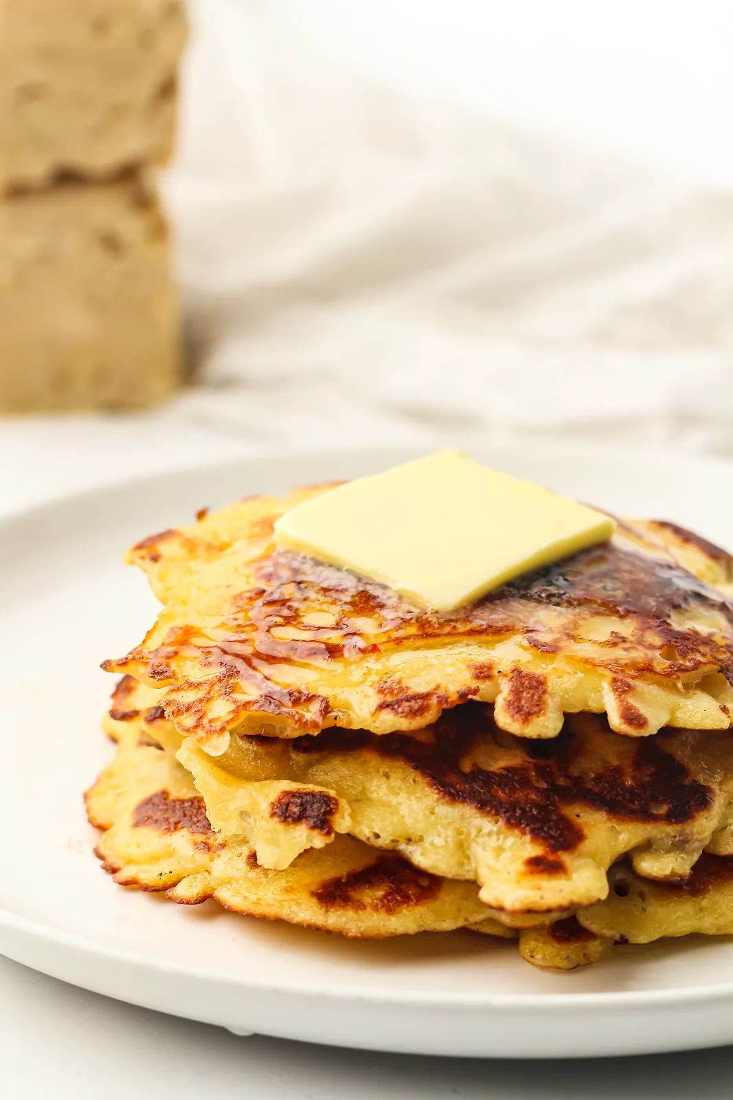 Lacy golden stack with a pat of butter melting on top