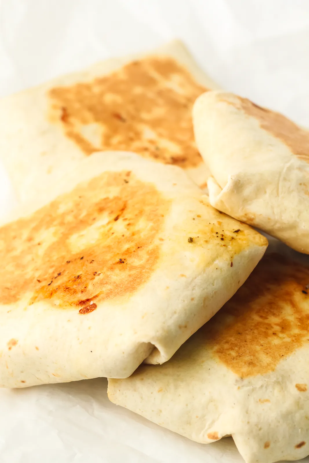 Close up of griddle browned tortilla parcels with crisp golden patches