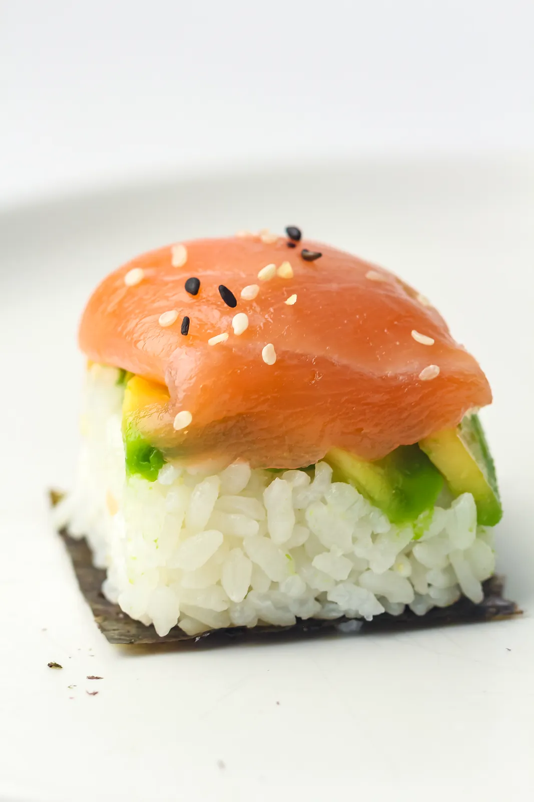 Ice cube tray sushi: a smoked salmon topped rice cube with avocado on a square of nori