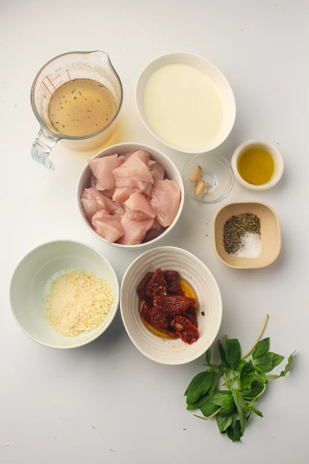 Ingredients for marry me chicken: diced breast, broth, heavy cream, olive oil, garlic, salt and pepper, Parmesan, sun-dried tomatoes and basil