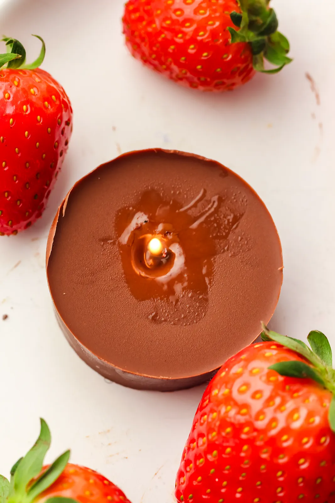 Overhead view of a glossy pool of melted chocolate around a small flame