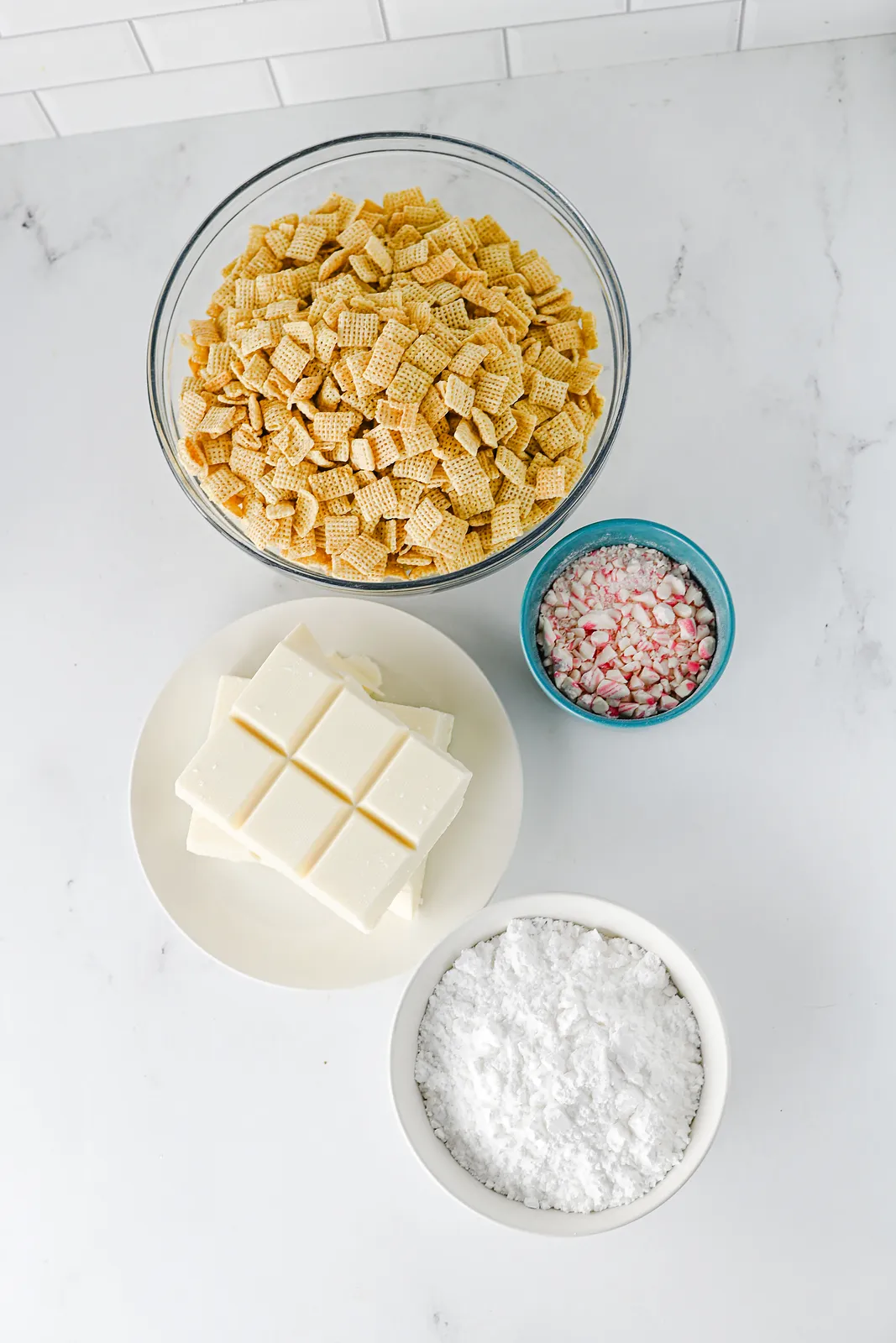 Ingredients for peppermint puppy chow: rice Chex, white almond bark, crushed candy canes and powdered sugar