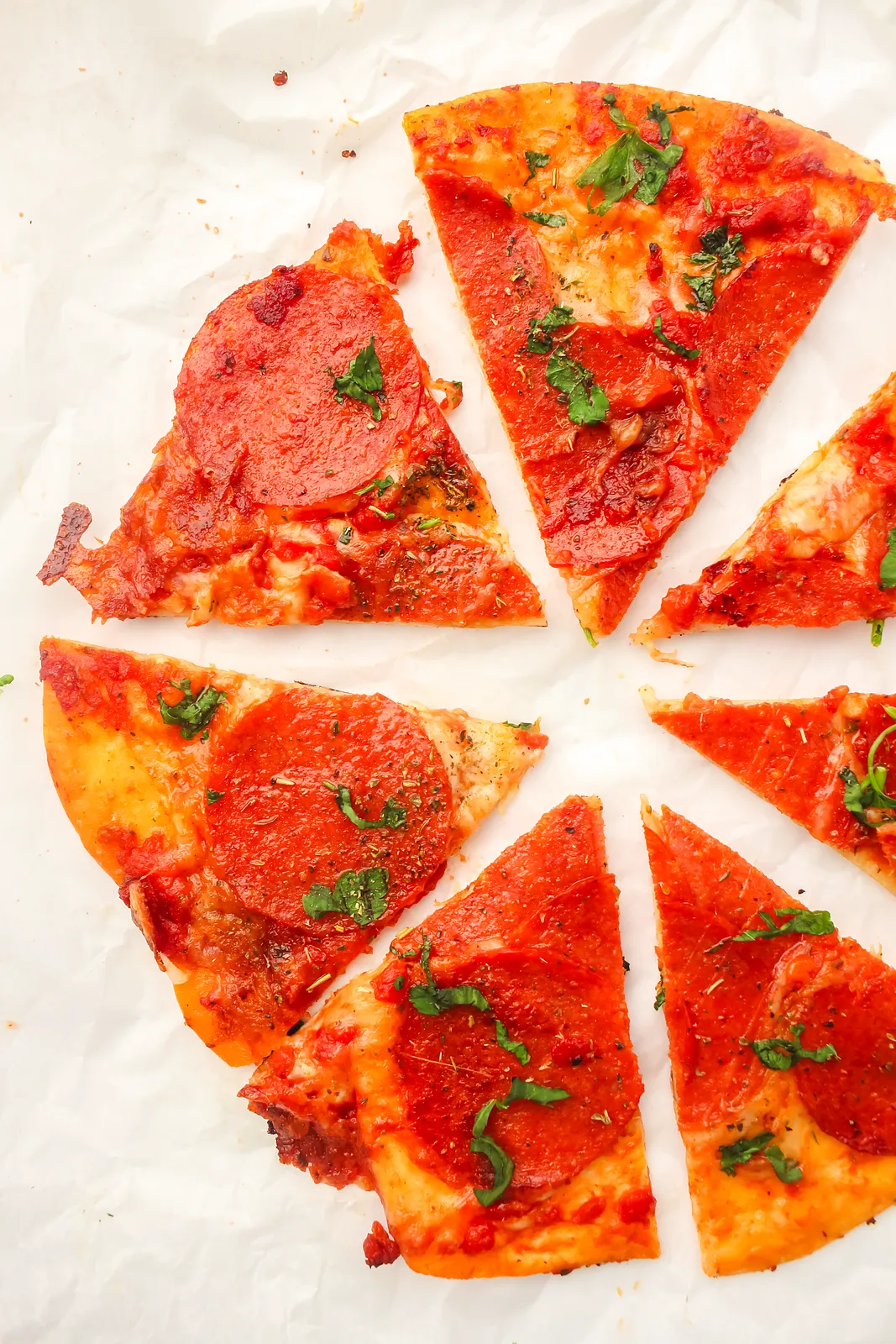 Crispy pepperoni wedges spread out on baking paper
