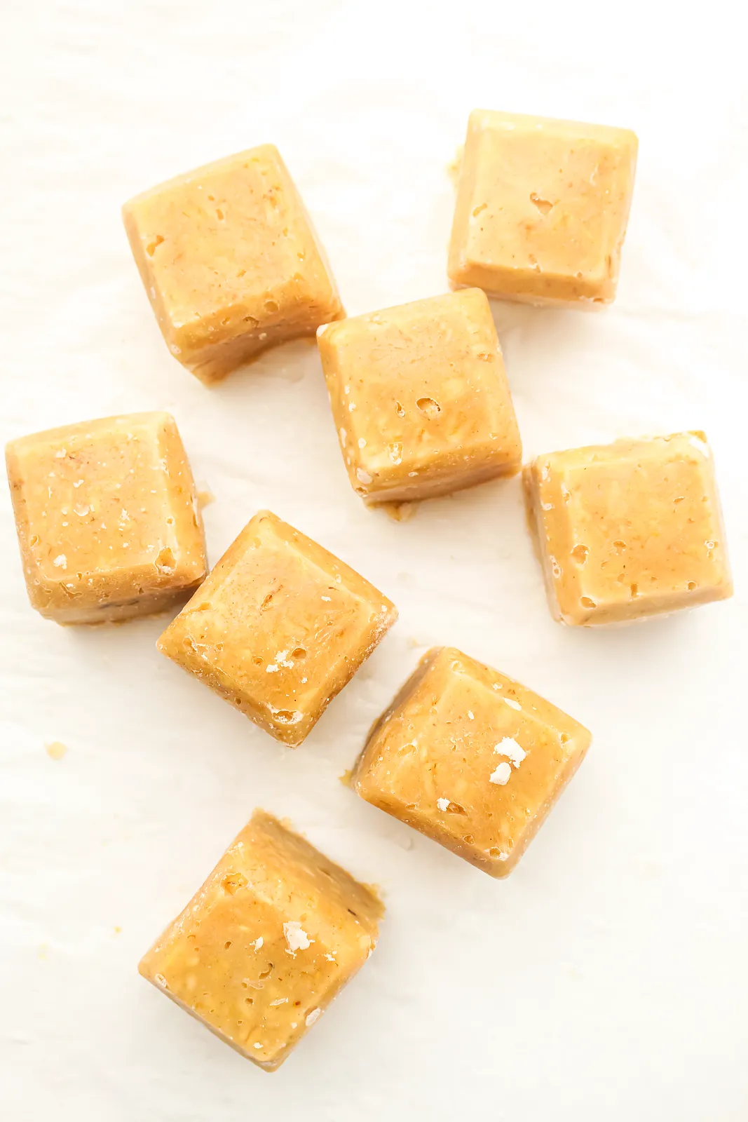 Golden porridge portions scattered across white parchment, seen from above