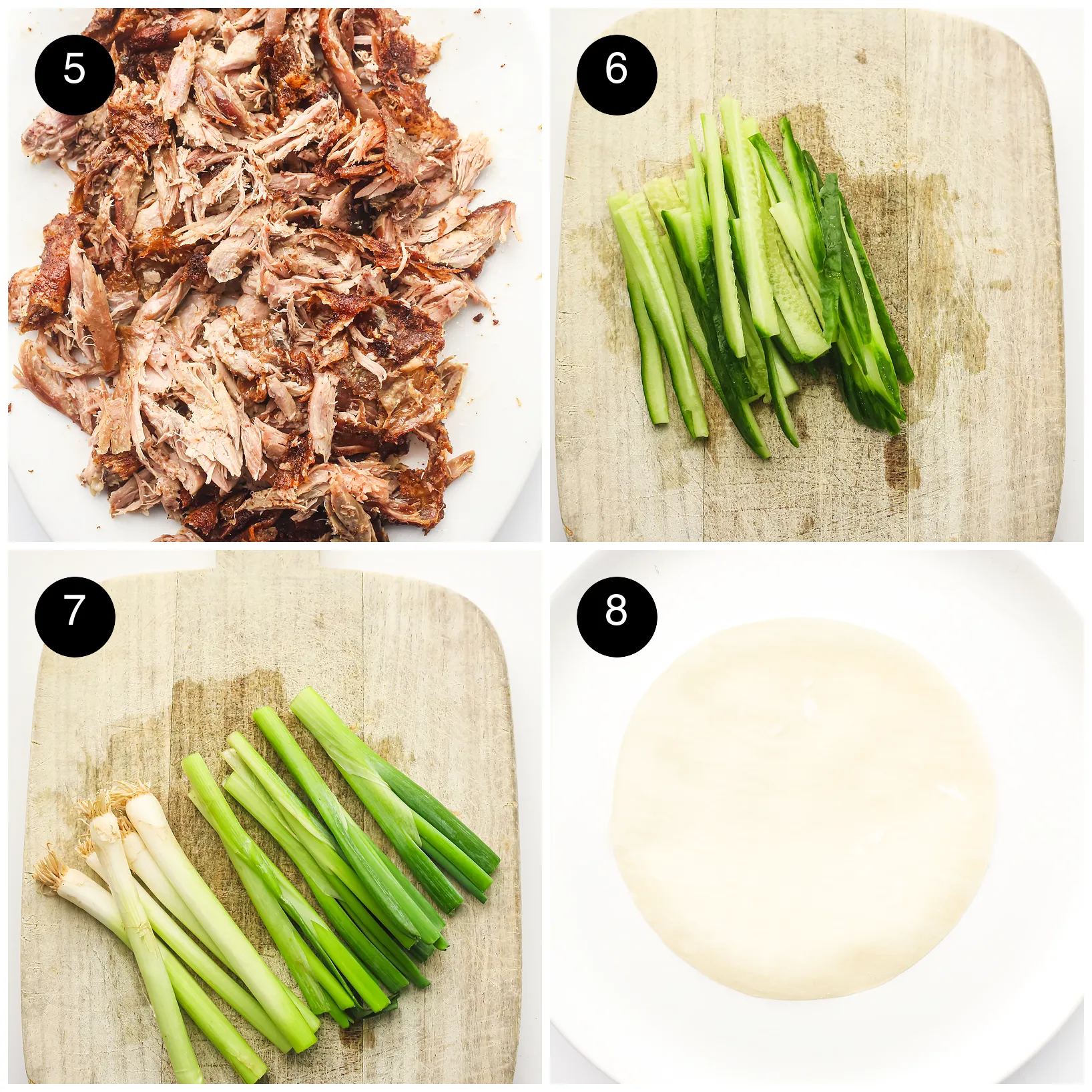 Shredded crispy meat, cucumber batons, trimmed spring onions and a thin wrapper on a plate