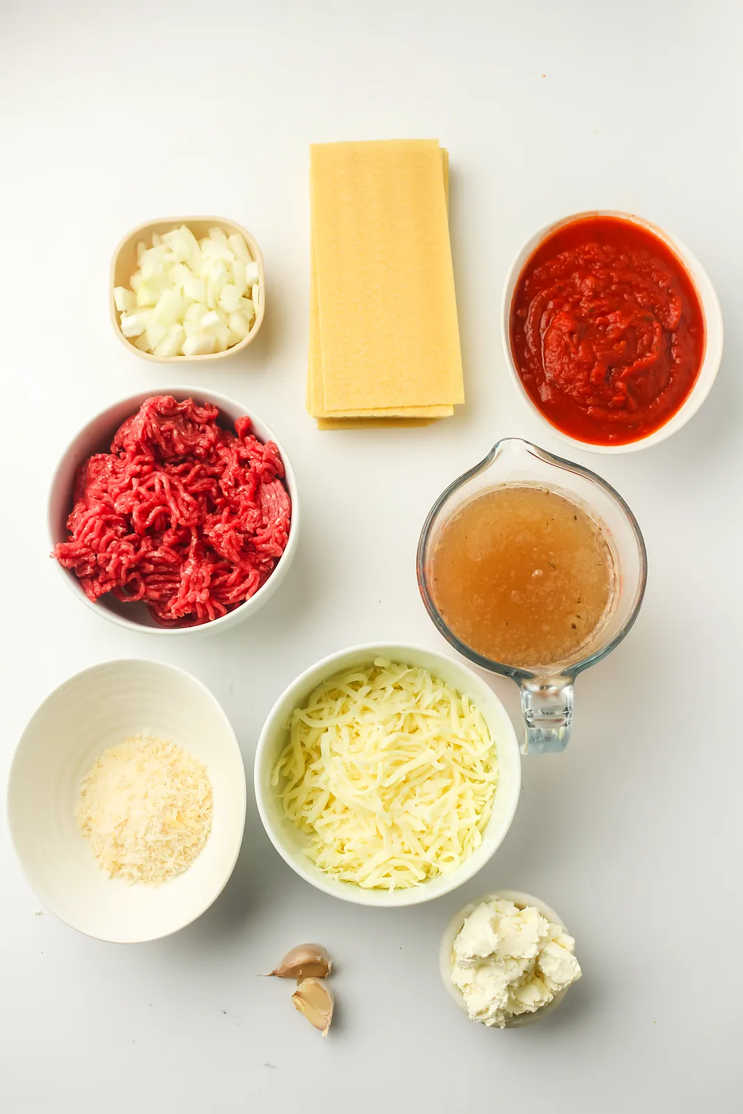 Ingredients for skillet lasagna: beef mince, onion, garlic, marinara, beef stock, lasagna sheets, ricotta, mozzarella and Parmesan
