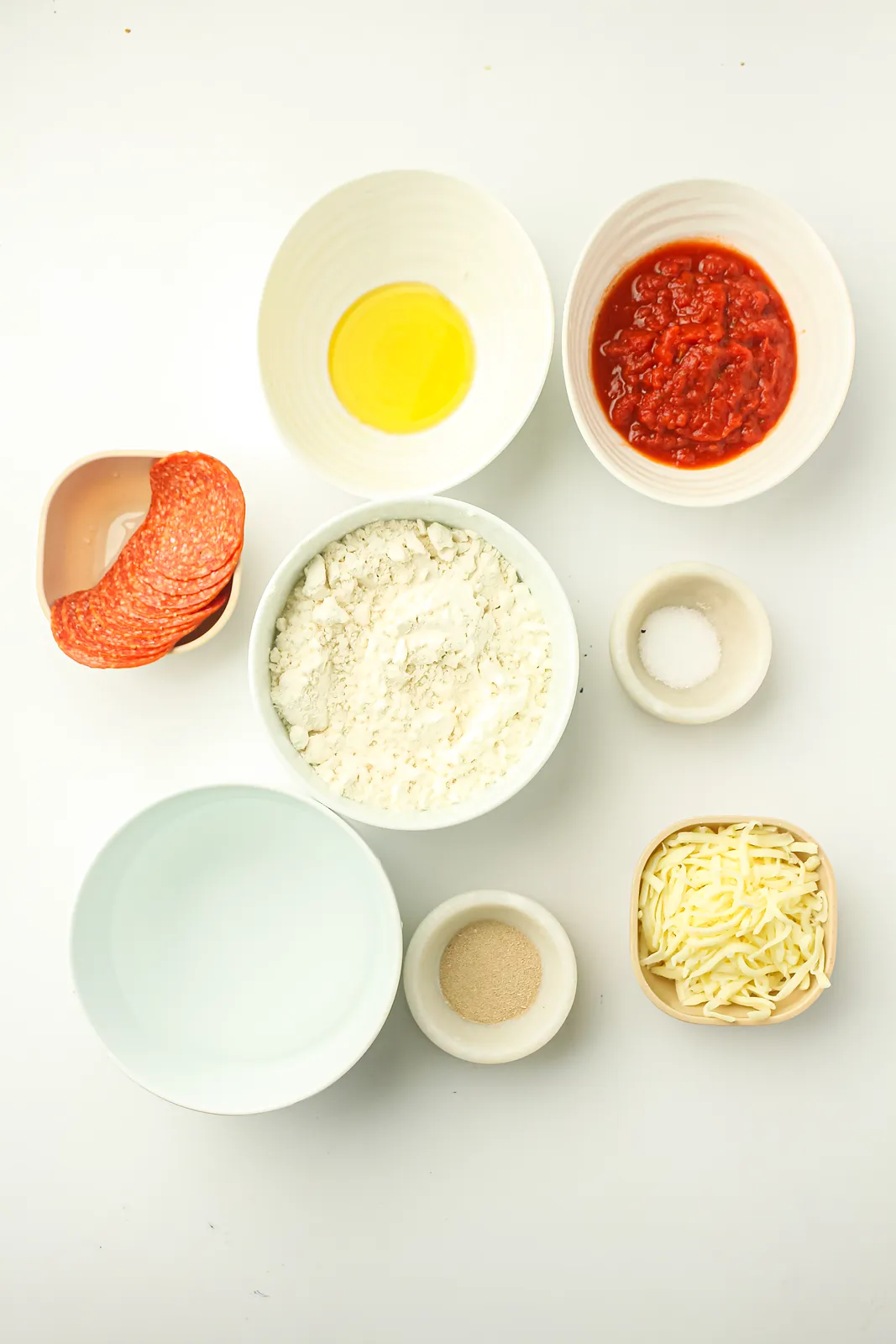Ingredients for skillet pizza: flour, instant yeast, salt, warm water, olive oil, pizza sauce, mozzarella and pepperoni