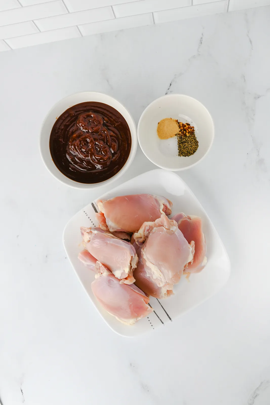 Ingredients for slow cooker BBQ chicken thighs: boneless skinless thighs, barbecue sauce, salt, pepper, garlic powder and red pepper flakes