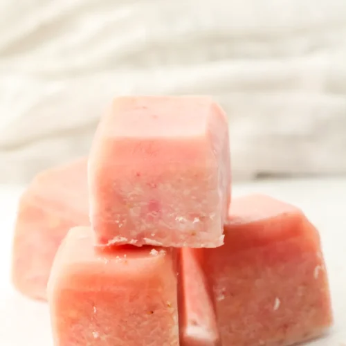 Strawberry banana smoothie cubes stacked on a white surface