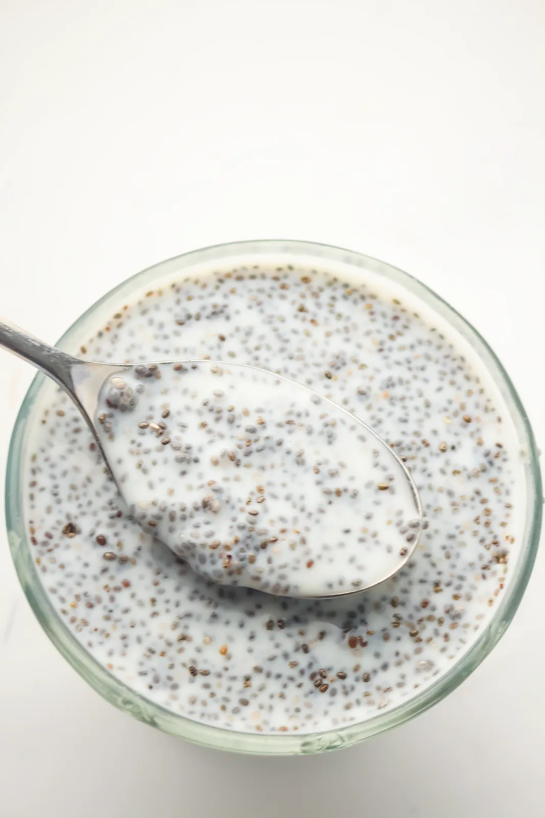 A spoon lifting a creamy, speckled spoonful from a glass bowl