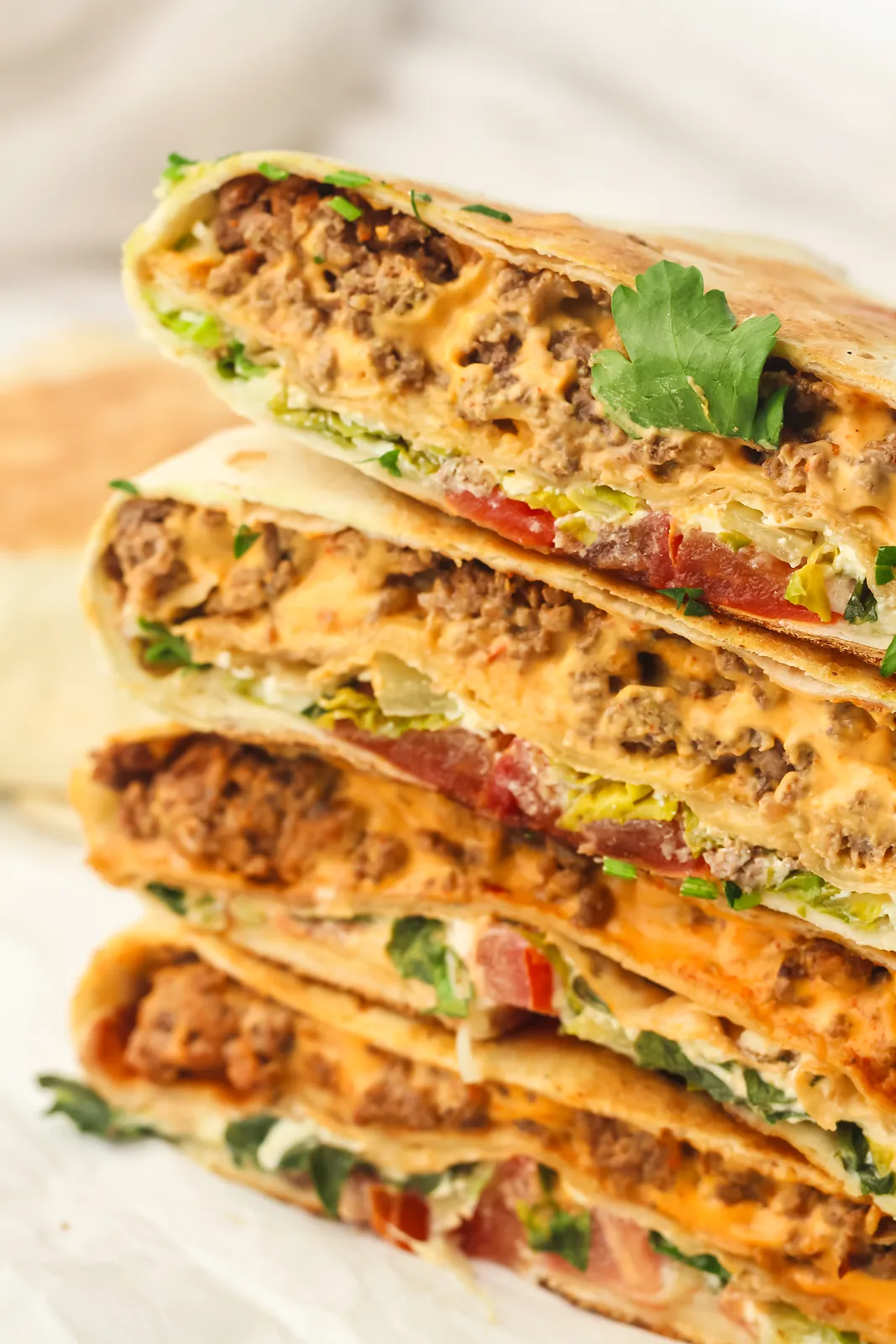 Four halves stacked high showing the seasoned mince, cheese sauce and fresh salad filling