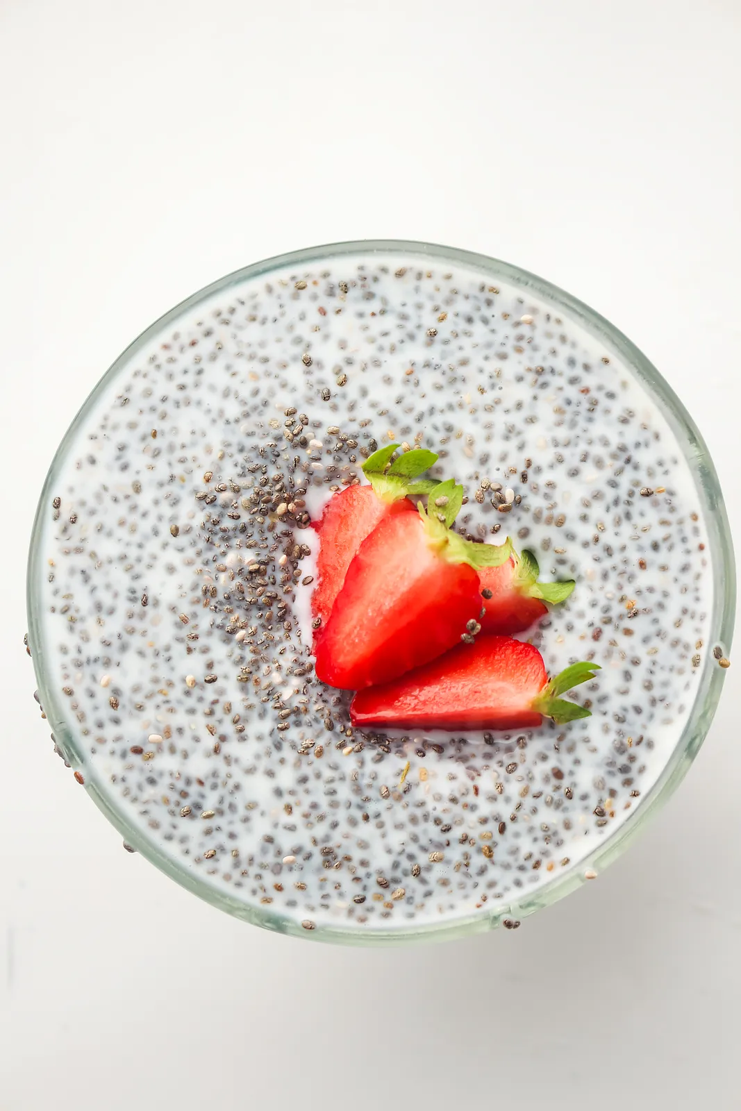 Overhead glass of thick seeded cream topped with strawberries